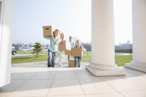Movers carrying furniture carefully into a Coulsdon property