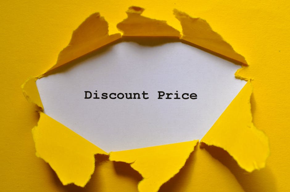 A yellow paper surface with a circular hole torn in the middle, revealing a white paper backing behind it. Printed on the white paper is the text 'Discount Price' in black, typewriter-style font. The torn edges of the yellow paper are rugged and uneven, creating a layered, three-dimensional effect. The scene is well-lit, with soft shadows cast by the torn edges, emphasizing the texture of the paper. This image could be associated with promotional discounts or special offers related to home removal or relocation services, such as those provided by Man With a Van Coulsdon, where careful handling and moving logistics are involved in house removals, furniture transport, and packing processes.